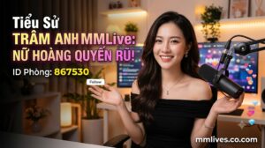 Banner hồ sơ idol Trâm Anh MMLive, giới thiệu 'Nữ hoàng quyến rũ!' với ID phòng 867530. Hình ảnh một nữ streamer trẻ mỉm cười trước thiết bị livestream, với các biểu tượng trái tim và kim cương bay lên. Bao gồm domain artsmentoring.co.